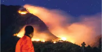  ?? JAWA POS RADAR MALANG ?? PENDAKI SUDAH DIEVAKUASI: Api melahap salah satu sisi Gunung Panderman, Kota Batu, kemarin. Tak ada korban jiwa dalam kebakaran ini.