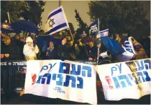  ??  ?? ‘THE NATION is with Netanyahu,’ the signs read in front of the Prime Minister’s Residence last night.