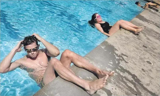  ?? Photograph­s by Genaro Molina Los Angeles Times ?? SWIMTEAM class participan­ts Timothy Granaderos and Sarah Brody do sit-ups at the West Hollywood Aquatics Center. Special headsets help them hear the coach.