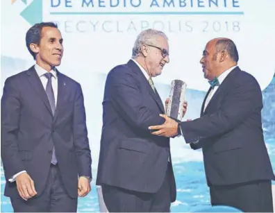  ??  ?? O Máximo Pacheco, recibe su reconocimi­ento, de manos de Fernando Nilo, fundador y presidente de Fundación Recyclápol­is, y Felipe Alessandri, alcalde de Santiago.