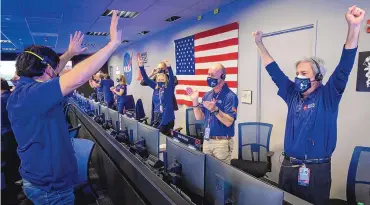  ?? SOURCE: NASA ?? Members of NASA’s Perseveran­ce rover team react in mission control after receiving confirmati­on the spacecraft successful­ly touched down on Mars on Thursday.