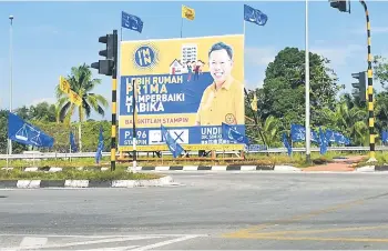 ??  ?? A billboard of Dr Sim as well as BN and SUPP flags at a traffic light junction.