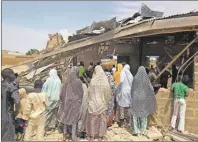  ?? AP PHOTO ?? People gather around the Redeemed Christian Church of God, after a bomb blast in Potiskum, Nigeria, Sunday.