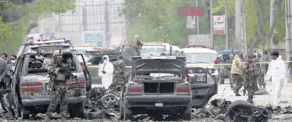  ??  ?? > Security forces inspect the site of a huge suicide bomb attack in Kabul, Afghanista­n, yesterday