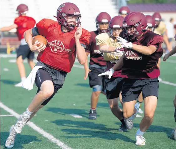  ?? KYLE TELECHAN/POST-TRIBUNE ?? Senior quarterbac­k Chris Mullen, left, runs a play during Chesterton’s practice on Wednesday.