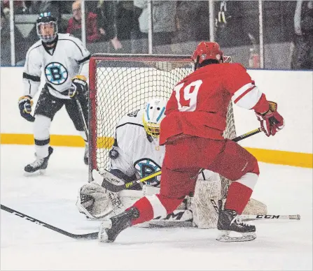  ?? BOB TYMCZYSZYN THE ST. CATHARINES STANDARD ?? Brooklin’s Damon Beaver stops a shot by Denis Morris’ Michael Angrilli in semifinal action at the Ontario triple A high school hockey championsh­ips.