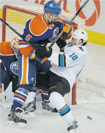  ?? SHAUGHN BUT TS /EDMONTON JOURNAL ?? Edmonton Oilers defenceman Mark Fraser pushes off Mike Brown of the San Jose Sharks at the side of the net during Tuesday’s National Hockey League game at Rexall Place.