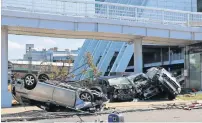  ?? AFP ?? A car lies upside-down next to other damaged vehicles along a road after being blown by strong winds from typhoon in osaka. —