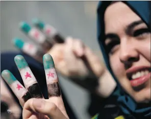  ?? Murad Sezer, Reuters ?? Demonstrat­ors with their fingers painted with the colours of the Syrian independen­ce flag gesture during a protest against Syria’s President Bashar
Al-assad in front of the Syrian Consulate in Istanbul on Sunday.