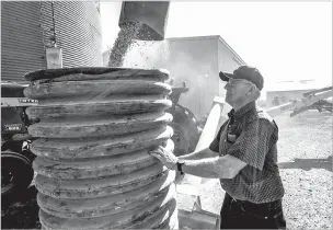  ??  ?? An auger transfers corn to a grain truck at the farm of Don Bloss on Thursday in Pawnee City, Neb. Farmers and agricultur­al economists are worried that President Donald Trump’s trade, immigratio­n and biofuels policies will cost farms billions of dollars in lost income and force some out of business.