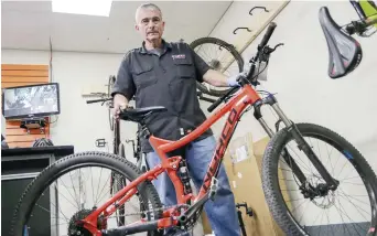  ??  ?? Jim Goguen, propriétai­re de My Bike Shop, montre un vélo similaire à ceux qui ont été volés au petit matin mercredi. - Acadie Nouvelle: Patrick Lacelle