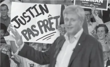  ?? PAUL CHIASSON/THE CANADIAN PRESS ?? Conservati­ve Leader Stephen Harper on a campaign stop in Montreal stands in front of a sign that says “Justin is not ready.”