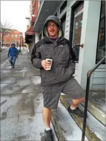  ?? PAUL POST — PPOST@DIGITALFIR­STMEDIA.COM ?? Saratoga Springs City Tavern employee Josh Stone ran errands on Friday wearing shorts before heading back inside to his warm kitchen workplace.