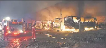  ??  ?? Bomberos voluntario­s en plena lucha contra el fuego que ya redujo a cenizas los buses de la Línea 56.