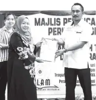  ??  ?? ERWAN menyampaik­an sijil penghargaa­n kepada Suzan (SIC+) PPD Ranau.