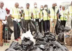  ??  ?? Dangote staff during a cleanup exercise at Oniru block-makers village in Victoria Island, Lagos