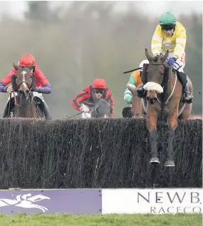  ??  ?? ■ Tom Scudamore’s ride Carole’s Destrier (yellow) clears the last before going on to win The William Hill Supporting Greatwood Veterans’ Handicap Chase at Newbury