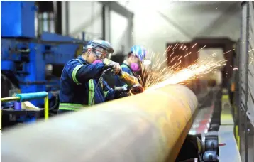  ??  ?? Workers are seen at Bri- Steel Manufactur­ing, a manufactur­er and distribute­r of large diameter seamless steel pipes, in Edmonton, Alberta, Canada. — Reuters photo