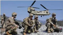  ?? AHN YOUNG-JOON / AP ?? U.S. Army soldiers wait to board their CH-47 Chinook helicopter during a joint military drill with South Korea in Pocheon, South Korea, on Sunday. North Korea appears to be ramping up missile-testing activities in response to the drills.