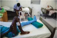  ?? AP PHOTO/ODELYN JOSEPH ?? Gladimy Trismer-Saint, who was shot in his left foot by a stray bullet, lies on a bed at a clinic run by Doctors Without Borders on Jan. 25 in the Tabarre neighborho­od of Port-auPrince, Haiti.