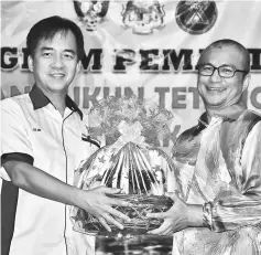  ??  ?? Hii (left) presenting a memento to Dr Annuar.