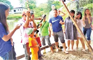  ??  ?? HAMDAN menghiburk­an pengunjung dengan tiupan sompotonny­a diiringi petikan gitar oleh rakannya.