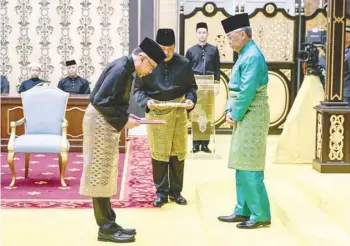  ?? Reuters ?? Malaysia’s King Al-sultan Abdullah (R) and Malaysia’s newly appointed Prime Minister Anwar Ibrahim take part in the swearing-in ceremony at the National Palace in Kuala Lumpur, Malaysia, on Thursday. —