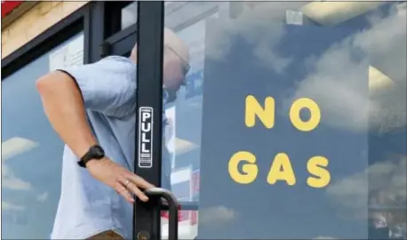  ?? ASSOCIATED PRESS ?? A customer walks into an Exxon filling station and convenienc­e store location where a sign on the door reads, “No Gas,” Thursday in Bedford, Texas. It’s getting harder to fill gas tanks in parts of Texas where some stations are out of fuel and pump costs are spiking.