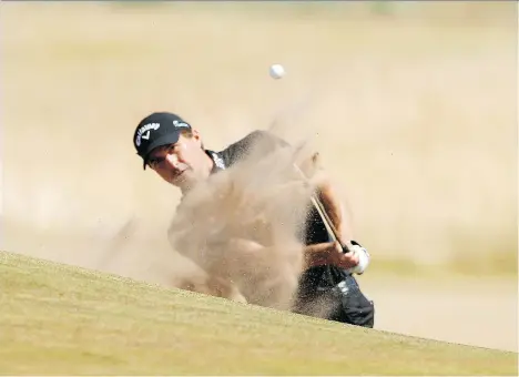  ?? ALASTAIR GRANT/THE ASSOCIATED PRESS ?? American Kevin Kisner plays a bunker shot on the 17th hole at Carnoustie en route to shooting a 5-under 66 to take the first-round lead on Day 1 of the British Open on Thursday in Carnoustie, Scotland. Sixteen other golfers were within three shots of Kisner.