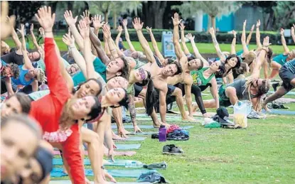  ?? PHOTOS BY SARAH ESPEDIDO/STAFF PHOTOGRAPH­ER ?? On Sunday, the lawn at Lake Eola Park at Eola Drive and Robinson Street downtown had about 100 yoga participan­ts of all ages and skills.