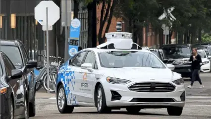  ?? Darrell Sapp/Post-Gazette ?? An Argo AI Ford Fusion self-driving car makes its way onto 24th Street from Smallman on Aug. 1, 2019, in the Strip District.
