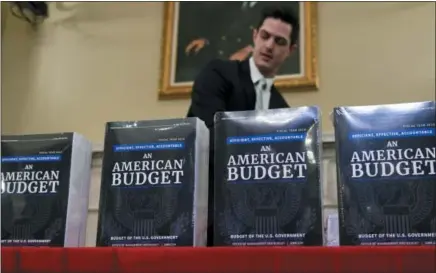  ?? THE ASSOCIATED PRESS ?? James Knable helps to unpack copies of the president’s fiscal year 2019 budget after it arrived Monday at the House Budget Committee office on Capitol Hill in Washington.
