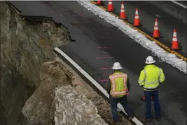  ?? GODOFREDO A. VÁSQUEZ — THE ASSOCIATED PRESS ?? Constructi­on workers look at the collapsed section of the southbound lane of Highway 1at Rocky Creek Bridge on April 4 in Big Sur.