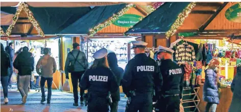  ?? FOTO: IMAGO ?? Polizisten bewachen den Weihnachts­markt in Essen. Nach dem Anschlag in Straßburg wurden die Sicherheit­smaßnahmen in NRW nicht weiter verschärft.