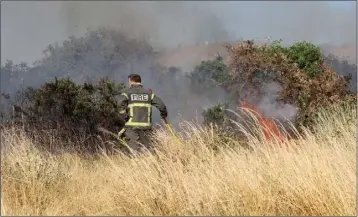  ??  ?? A fireman working to contain the blaze on Vinegar Hill.