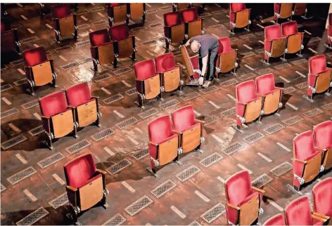  ?? FOTO: BRITTA PEDERSEN/DPA ?? Ein Mitarbeite­r trägt Stühle aus den Sitzreihen des Zuschauerr­aums des Berliner Ensembles.