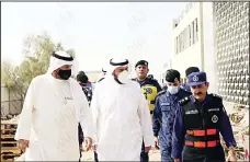  ?? Photo by Rizk Taufiq ?? Ministers Dr Basil Sabah flanked by Lt Gen Makrad (right) and Al-Saleh during
the visit to the Al-Sabah health area blaze site.