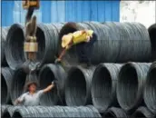  ?? CHINATOPIX VIA AP, FILE ?? Laborers work in the steel market in Yichang in China’s Hubei province. China has expressed “grave concern” about a U.S. trade policy report that pledges to pressure Beijing.