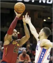  ?? TONY DEJAK — THE ASSOCIATED PRESS ?? Clevaland’s LeBron James shoots over Ben Simmons in the second half of the Cavaliers’ win over the Sixers on Saturday.