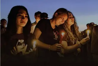  ??  ?? TURNING TRAGEDY INTO ACTION
ABOVE: People attend a candlelit memorial service for victims of the shooting at Marjory Stoneman Douglas High School that killed 17 people Feb. 15 in Parkland, Florida. The shooting sparked protests by students across the...