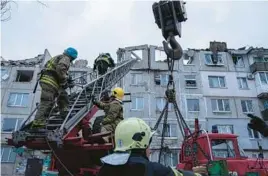  ?? EVGENIY MALOLETKA/AP ?? Rescue workers reach a residentia­l building Wednesday in Pokrovsk, Ukraine, after a Russian rocket attack Tuesday. Two people were killed and 12 injured there.