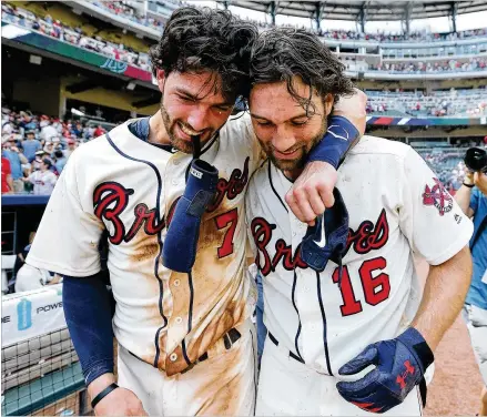  ?? CURTIS COMPTON/CCOMPTON@AJC.COM ?? Braves shortstop Dansby Swanson (left) and utilityman Charlie Culberson celebrate after Culberson’s pinch-hit, walk-off home run beat the Washington Nationals 4-2 on Sunday. Swanson had doubled the at-bat before Culberson’s winning shot.