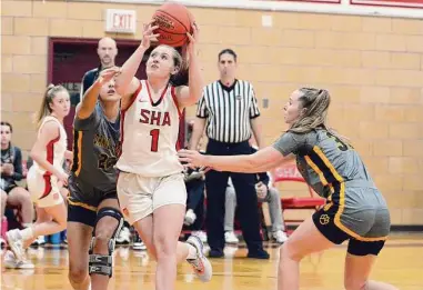  ?? Dave Phillips/For Hearst Connecticu­t Media ?? Emma Kirck of Sacred Heart Academy splits through a pair of Hand defenders in Aubrey Canth and Carson Miller on Friday.