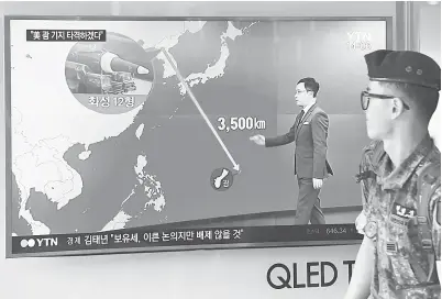  ??  ?? SEORANG askar Korea Selatan melintasi skrin TV menunjukka­n grafik jarak di antara Korea Utara dan Guam di sebuah stesen kereta api di Seoul.