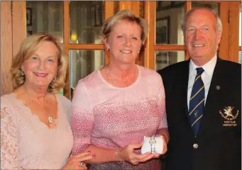  ??  ?? Carol Wickham, winner of the President’s Prize to the Ladies at L&B, is presented with her prize by President Donal Branigan and his wife Veronica.