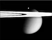  ?? NASA ?? In an image from Cassini, two of Saturn’s moons, the small Epimetheus and Titan orbit past two rings.