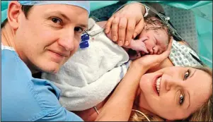  ??  ?? Just born: Elijah nestles in the arms of Mrs Strange and her husband Neil