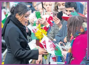  ??  ?? DAFFY FOR MEG: She is presented with bunch of daffodils at Cardiff Castle