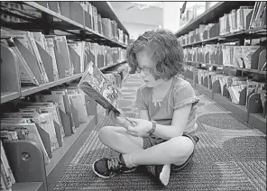  ?? NWA Democrat-Gazette/BEN GOFF ?? Tessa Thompson, 10, of Fayettevil­le, who gets services through Medicaid, browses books Saturday at the Fayettevil­le Public Library. For now, Medicaid is open-ended, meaning it gives coverage to all who qualify. A bill proposed in the U.S. Senate would...