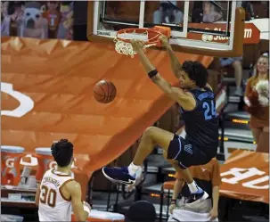  ?? MICHAEL THOMAS - THE ASSOCIATED PRESS ?? Jeremiah Robinson-Earl, here dunking in a win in Austin over the University of Texas, and his Villanova teammates have played in empty arenas this season. But Wednesday’s home opener in a vacant Pavilion will be a new experience.